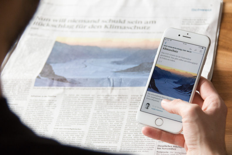 Mann liest Zeitung auf dem Smartphone