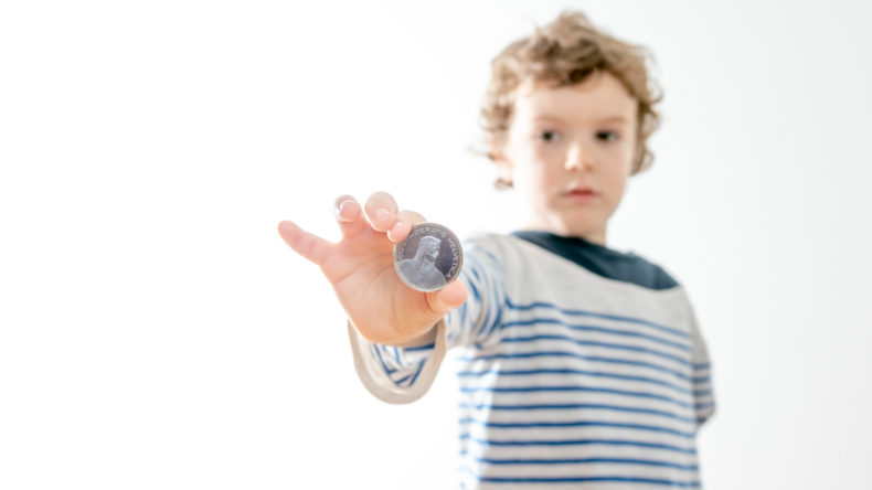 kleiner Junge mit Fünfliber in der Hand