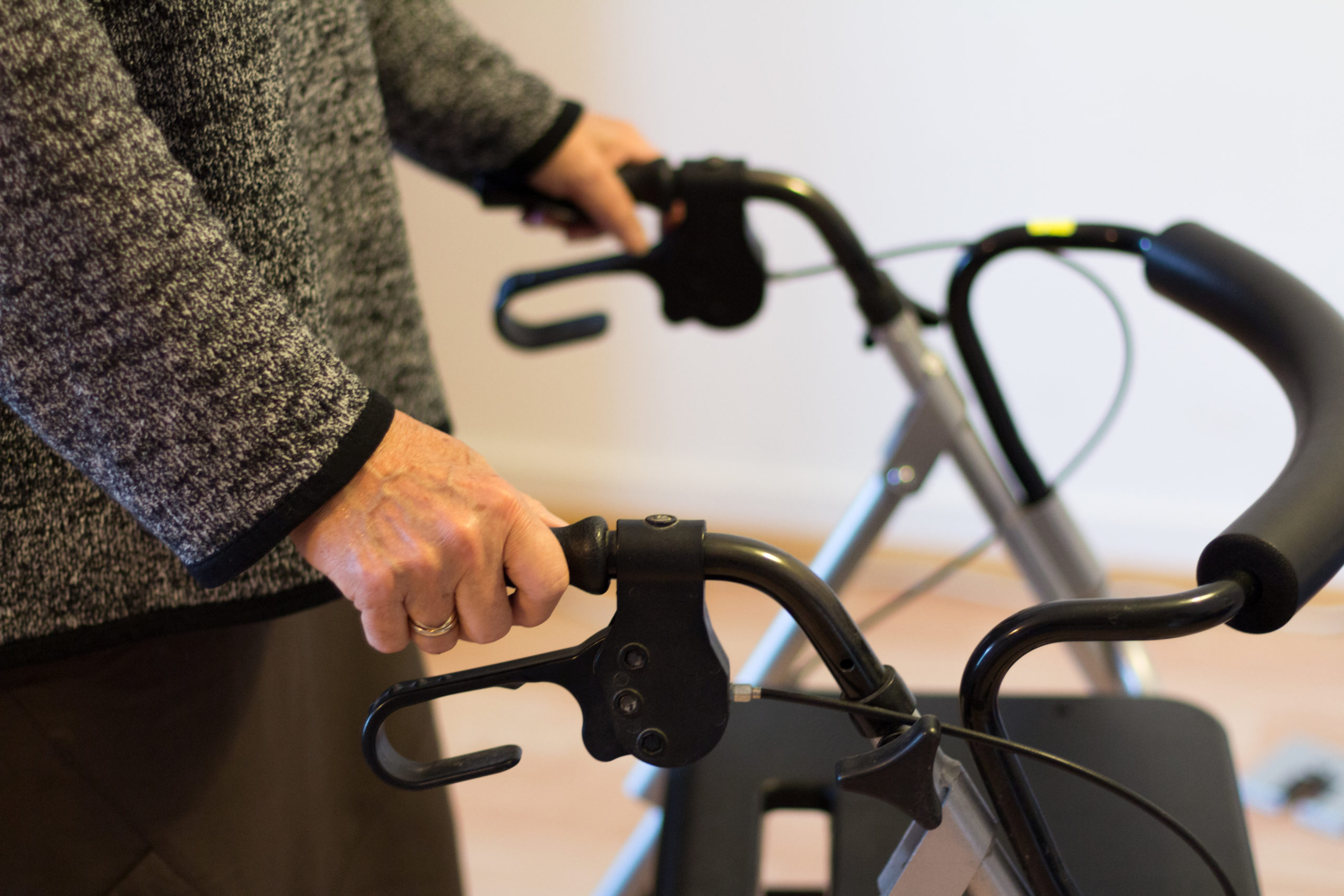 Eine betagte Frau stützt sich auf ihren Rollator.